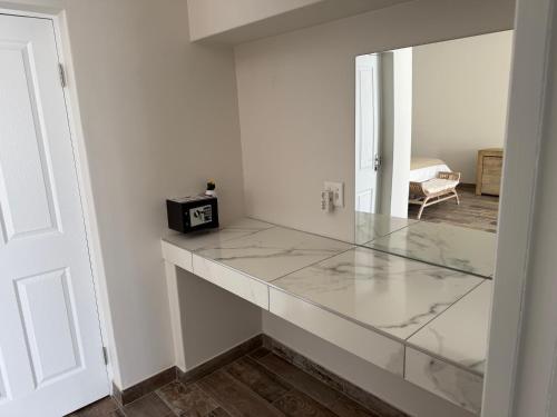 a glass counter in a room with a mirror at Berg & Baai guesthouse in Plettenberg Bay