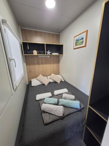 a small room with a bed with towels on it at SUNNY Rest Nest in Pakoštane