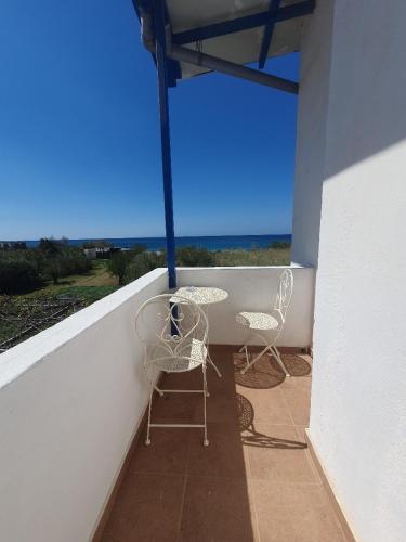 a patio with two chairs and a table on a balcony at Babis & Popi Rooms and Studios in Frangokastello