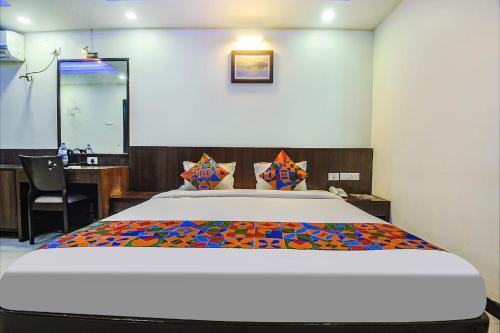 a bedroom with a large bed and a desk at Hotel Shakti Palace in Ponda