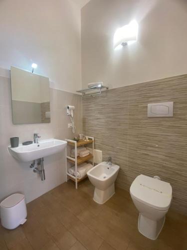 a bathroom with a white toilet and a sink at B&B La mia Isola in Castelluzzo