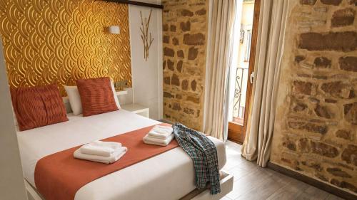 a bedroom with a bed with towels on it at HOTEL FUENTE REDONDA LUXURY in Úbeda