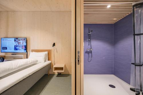 a bedroom with a shower and a bed and a television at RS Noatun in Horten