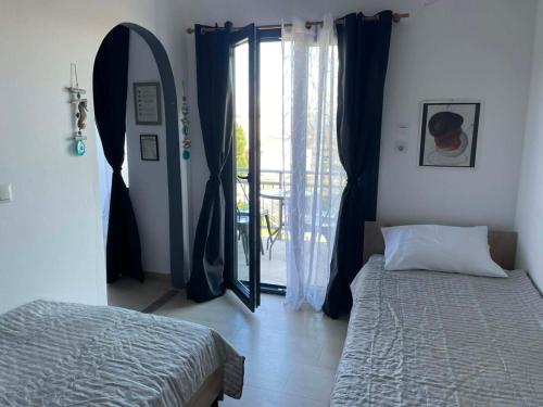 a bedroom with a bed and a mirror and a window at Vesper Rooms in Skala Prinou
