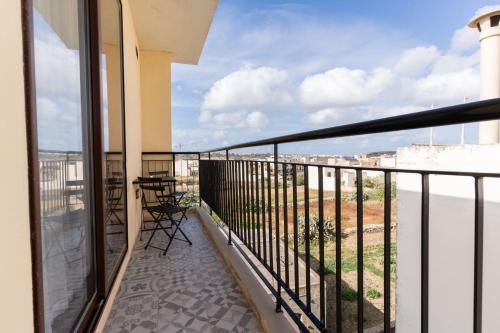 a balcony with chairs and a view of the city at Quaint Boutique Hotel Xewkija in Xewkija