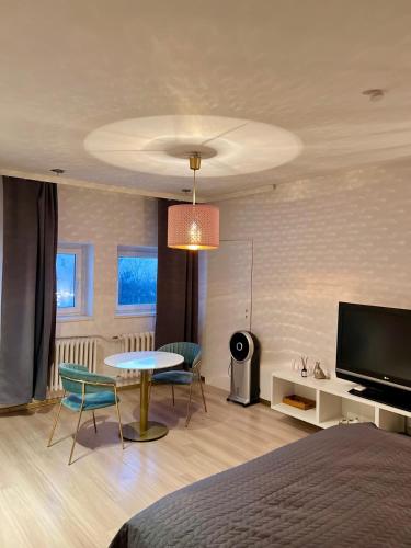 a bedroom with a bed and a table and a tv at Apartament Blue Monte 60 in Sopot