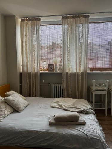 a bed with two pillows sitting on it in front of a window at Apartament Boho Monte 60 in Sopot