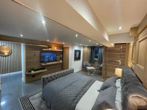 a bedroom with a large bed and a television at Hendham House - Near Etihad Stadium, CoOp Live Arena, AO Arena, Piccadilly Train Station & Manchester City Centre in Manchester