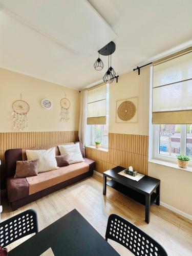 a living room with a couch and a table at Przy Parku Róż II in Chorzów