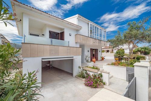 a white house with a patio and a yard at Villa Magraner by Sealand Villas in Can Picafort