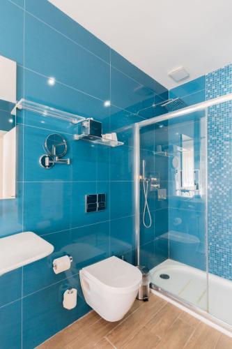 a blue bathroom with a toilet and a shower at Quaint Boutique Hotel Xewkija in Xewkija