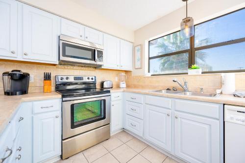 a kitchen with white cabinets and a stove top oven at Lei Lani 108 condo in Orange Beach