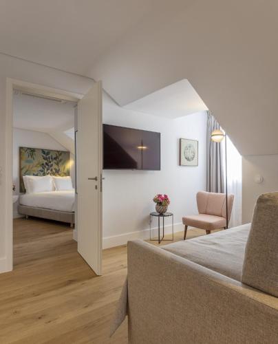 a hotel room with a bed and a chair at LSA Madalena by Numa in Lisbon