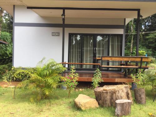 a house with a bench in the grass at House at island Chang in Ban Map Khangkhao
