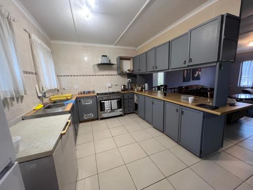 a large kitchen with black cabinets and a white tile floor at Prime Leisure in Margate