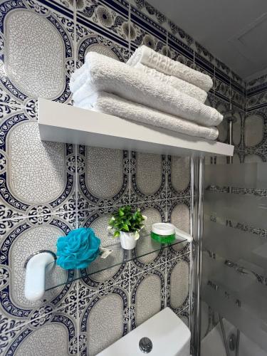 a bathroom with a shelf with towels and plants at Perlazul in Peniscola