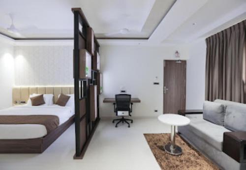 a bedroom with a bed and a desk with a chair at Nandha Grande in Udumalaippettai