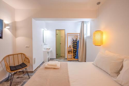 a bedroom with a white bed and a chair at Depis luxury private villas in Plaka