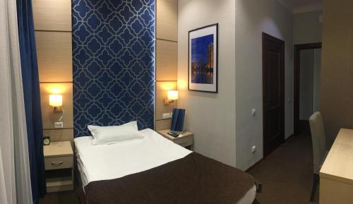 a hotel room with a bed and a blue wall at Orynbor Boutique Hotel in Astana