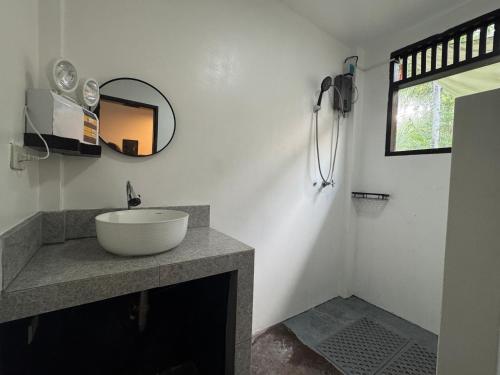 a bathroom with a sink and a mirror at Nutmeg Cottage SIARGAO 2BR exclusive whole house in General Luna