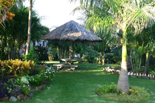 a park with a picnic table and a straw umbrella at Shankars Resort in Guwahati