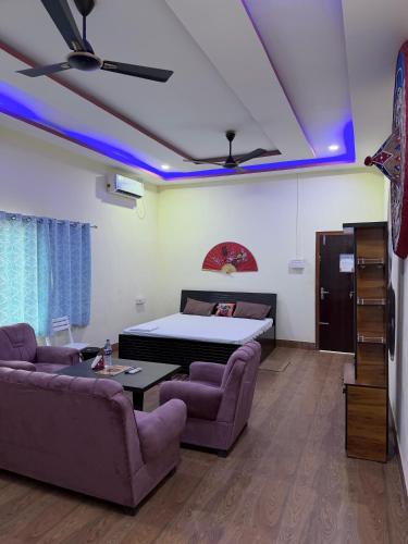a room with a bed and a couch and a table at Shankars Resort in Guwahati
