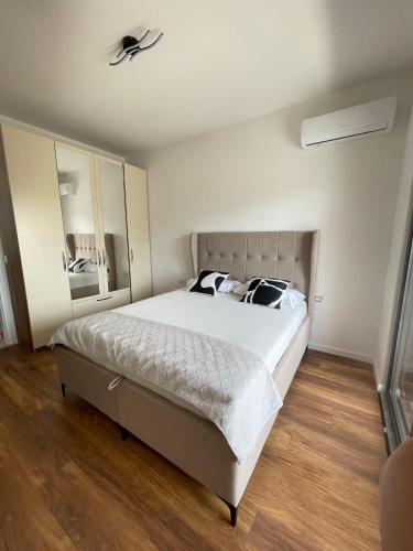 a bedroom with a large white bed and a mirror at Bliss by the Sea in Ulcinj