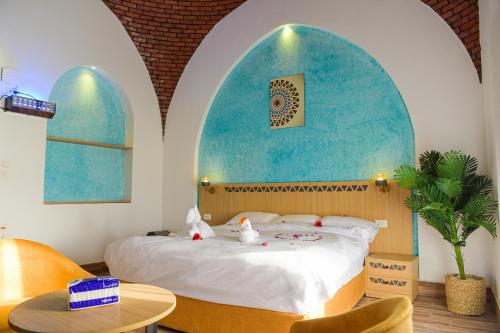 a bedroom with a bed with a blue wall at New Panorama Resort in Fayoum
