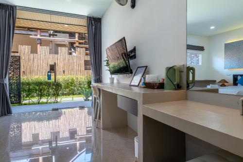 a bedroom with a large window and a bed at The Strand Resort Samui in Bangrak Beach