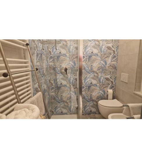 a bathroom with a toilet and a shower curtain at Castelli di sabbia in Levanto