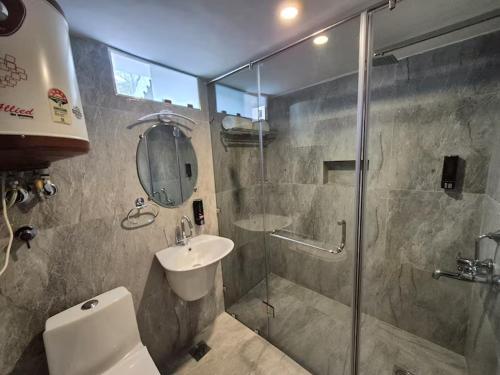 a bathroom with a shower and a toilet and a sink at The Pinus Resort in Pahalgām
