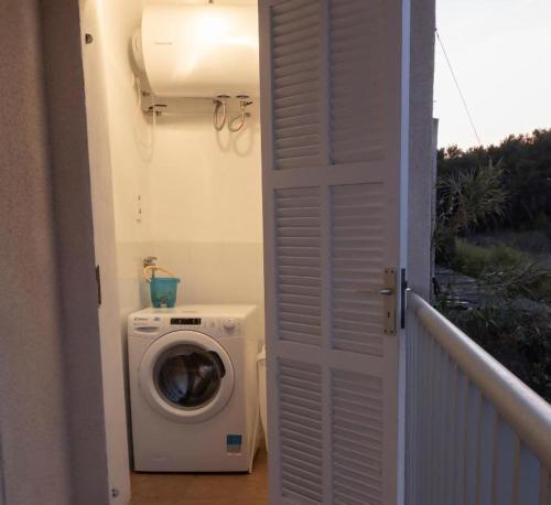 a washer and dryer in a room with a door at APARTAMENTO EL ROJO in Can Picafort