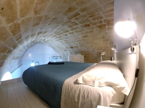 ein Schlafzimmer mit einem Bett und einer Steinmauer in der Unterkunft Idris Loft Matera in Matera