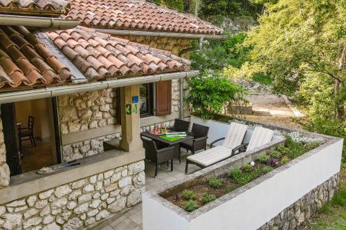 an external view of a stone house with a table and chairs at Campsite & Holiday Resort Medveja -by Liburnia Hotels & Villas in Medveja
