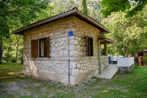 a small stone house in the middle of a yard at Campsite & Holiday Resort Medveja -by Liburnia Hotels & Villas in Medveja