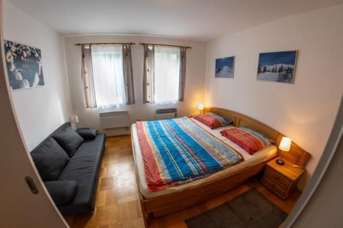 a small bedroom with a bed and a couch at Apartmán Grimming in Tauplitz