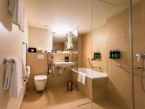 a bathroom with a sink and a toilet and a shower at Crowne Plaza Zürich by IHG in Zurich