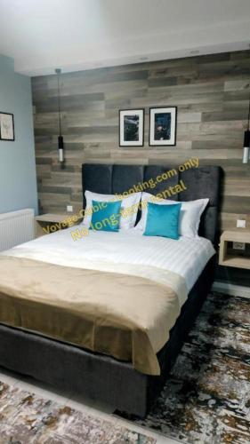 a bedroom with a large bed with blue pillows at VOYAGE CUBIC Adults Only in Sibiu