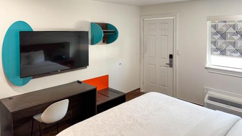 a bedroom with a bed and a tv on a wall at Motel 6 Classic Galveston, TX Beach-Seawall in Galveston