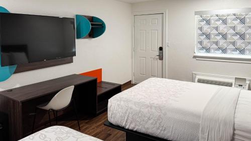 a bedroom with a bed and a desk and a tv at Motel 6 Classic Galveston, TX Beach-Seawall in Galveston