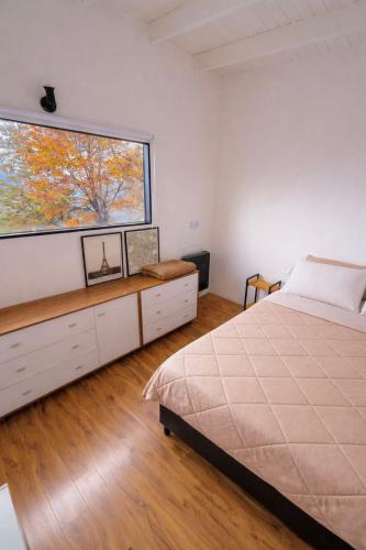 a bedroom with a bed and a large window at CIELO AUSTRAL house overlookin the ocean in Ushuaia