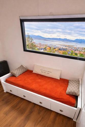 a bed in a room with a large window at CIELO AUSTRAL house overlookin the ocean in Ushuaia