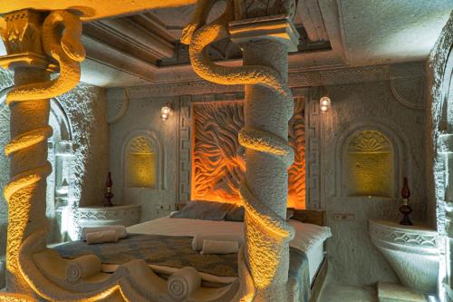 a bedroom with a bed with a large snake sculpture at Tyana Cave House in Nar