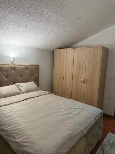 a bedroom with a large bed and wooden cabinets at Apartment NAV in Plav