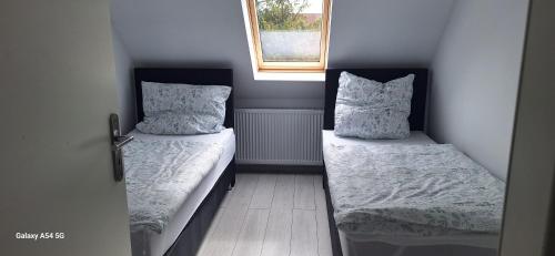 a small room with two beds and a window at Ferienwohnung am Waldrand 1 in Stary Przybsław