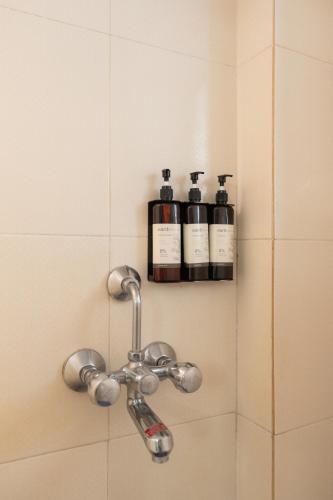 a shower with three bottles of wine on a shelf at Victor Exotica An Indy Resort in Candolim