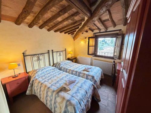 a bedroom with two beds and a window at Le Torri View Apartment - San Gimignano in San Gimignano