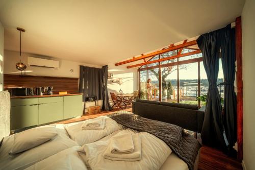a bedroom with a large bed and a large window at Pillanat Wellness Kabin in Bánk
