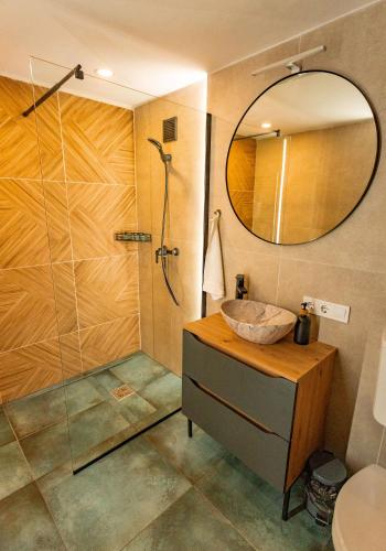 a bathroom with a shower and a sink and a mirror at Pillanat Wellness Kabin in Bánk