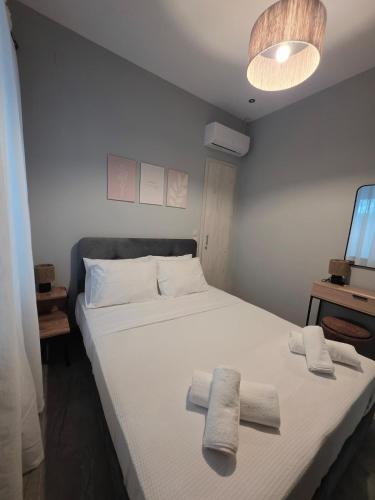 a bedroom with a white bed with towels on it at SeDi Cozy Apartment in Chios